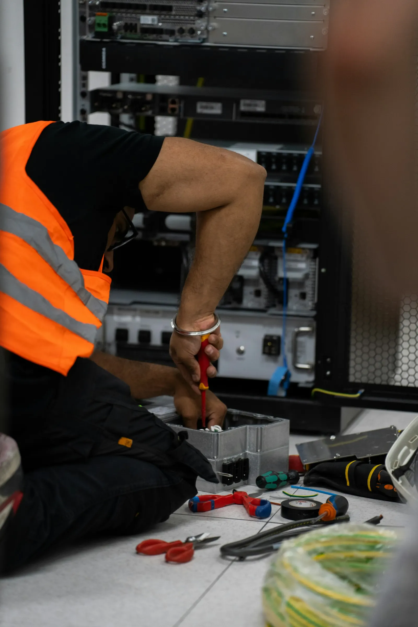 Technicien travaillant sur un équipement réseau avec ses outils